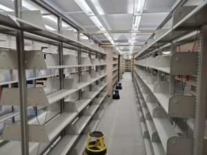 A long row of empty bookshelves in the GSU library wait for removal.