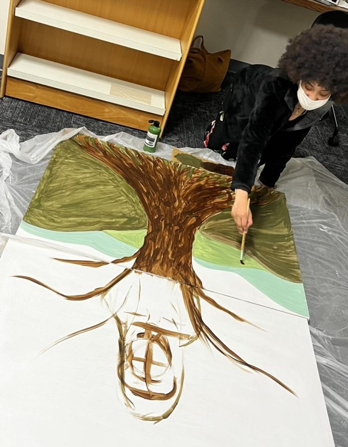 Latia Jackson works on the mural honoring LaNiyah Murphy.