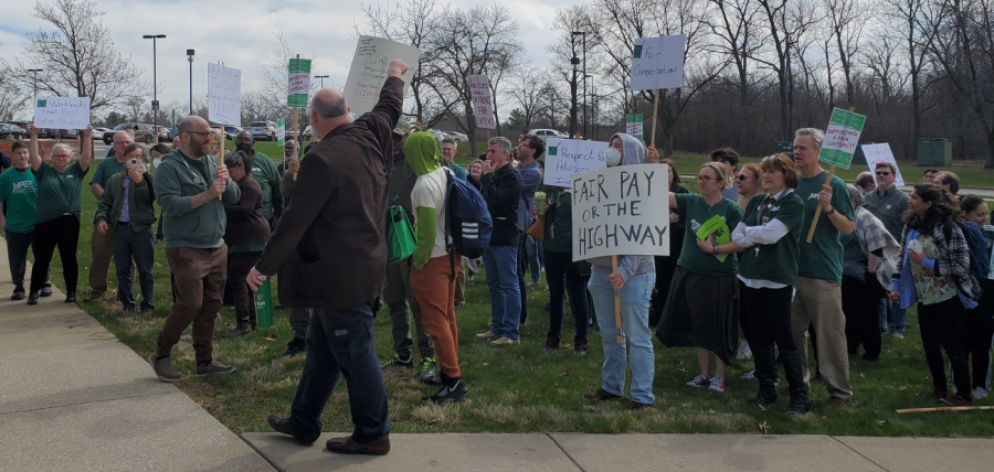 Union president Mike Hart raises his hand to encourage  students in their support of faculty demands.