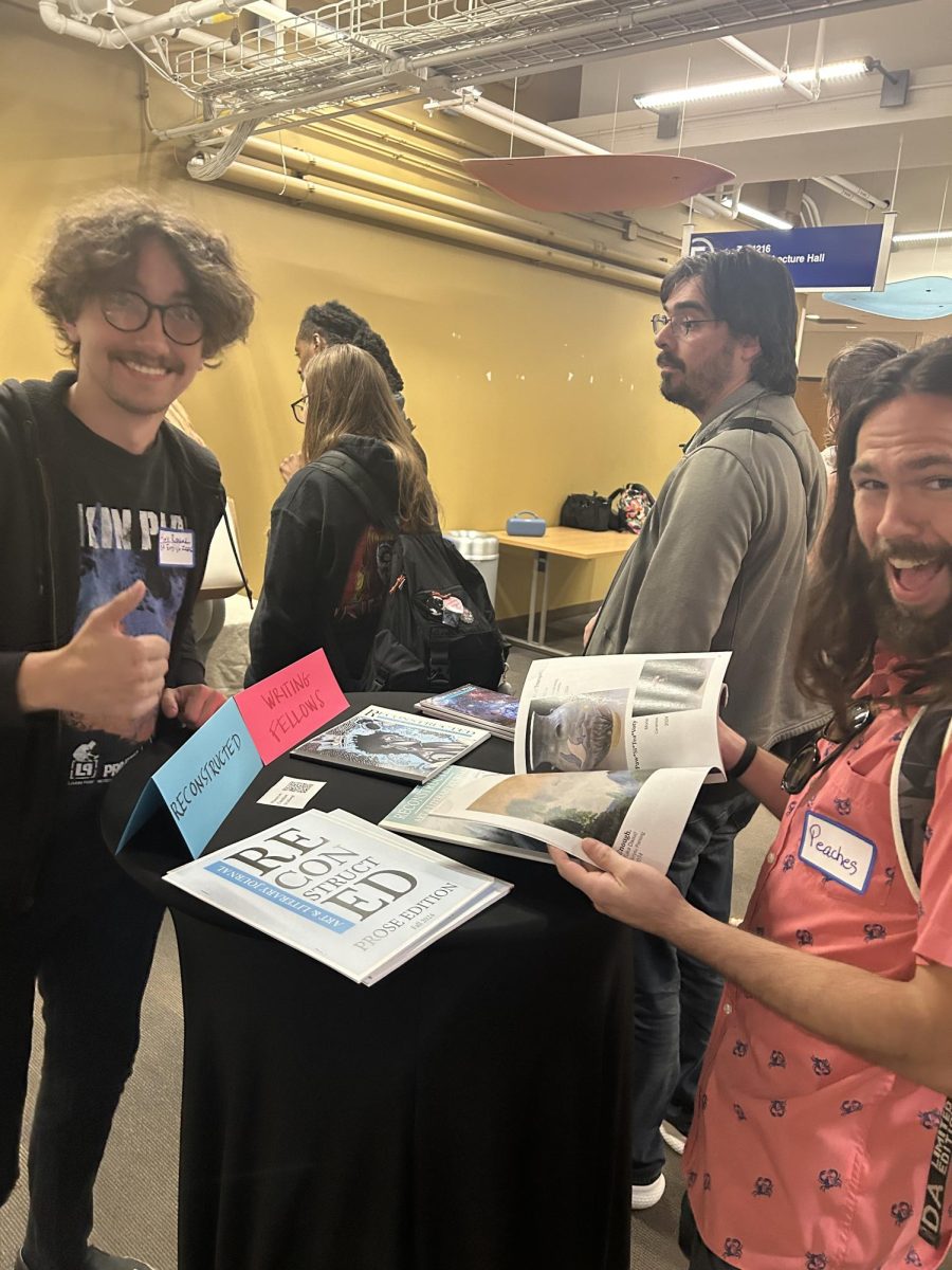 Alex Randak (left) and Aron Peach (far right) peruse the books at the English Dept mixer. 