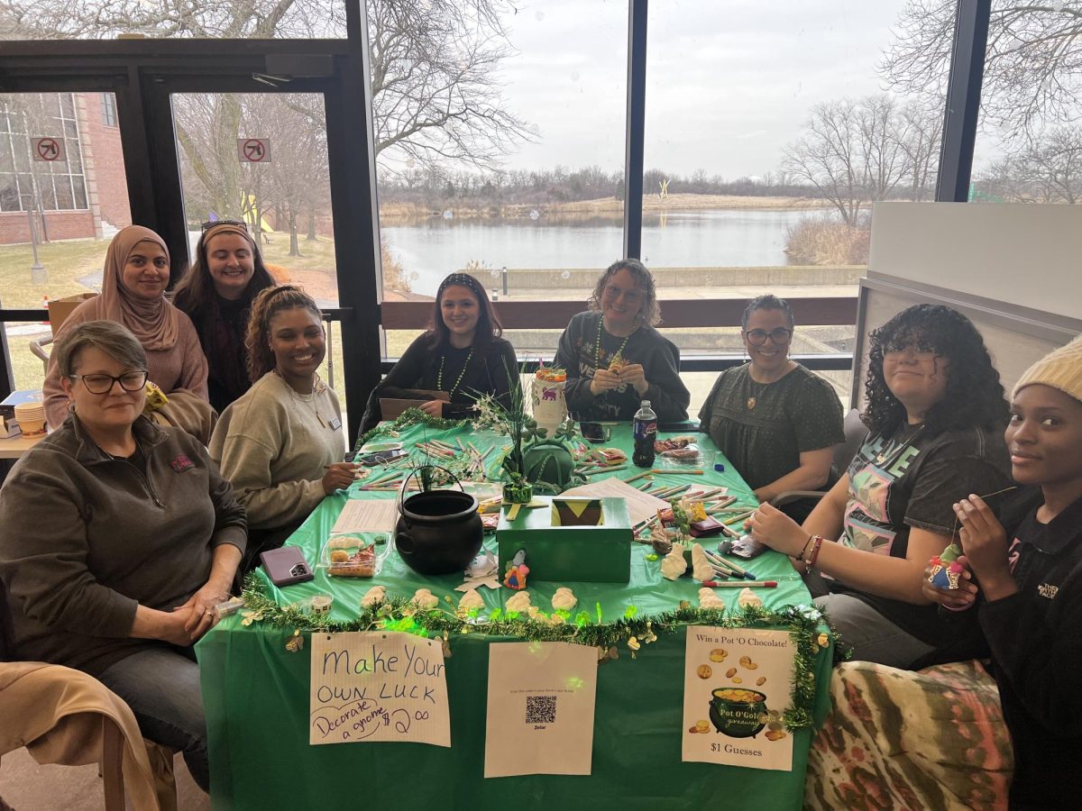 Students gather around a decorated table during the “Make Your Own Luck” St. Patrick’s Day fundraiser hosted by Psi Chi in the Hall of Governors atrium at Governors State University. Participants created bookmarks and decorations while taking part in a “Pot O’ Gold” chocolate guessing contest. 