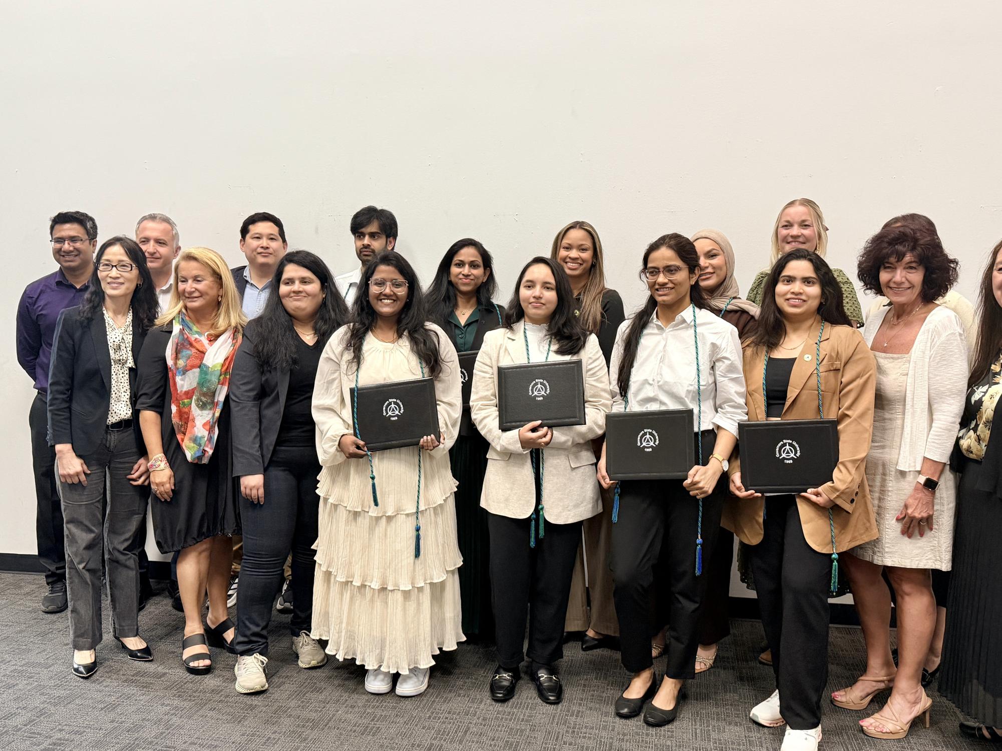 Newly inducted members of the Upsilon Phi Delta Class of 2026 gather in the E-Lounge at Governors State University on April 21 following the induction ceremony.